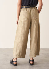 A woman wearing like green linen wide leg cargo trousers and a black t-shirt