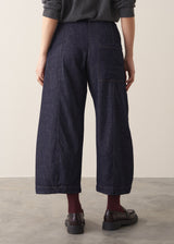 Woman wearing a grey sweater and dark blue wide leg cargo jeans and brown loafers