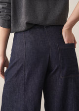 Woman wearing a grey sweater and dark blue wide leg cargo jeans, close up of pocket detail