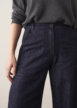 Woman wearing a grey sweater and dark blue wide leg cargo jeans
