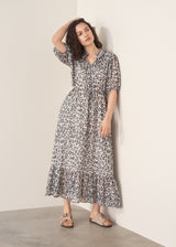 Woman wearing grey leopard print dress and nude sandals