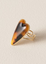 Heart-shaped ring with tortoiseshell design on a beige background