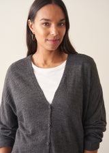 Woman wearing a light charcoal grey cardigan with leopard print trousers and a white t-shirt.