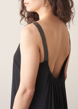 Black sleeveless top with open back worn by a person on a plain background