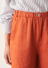 Woman wearing striped shirt and red linen shorts with sandals