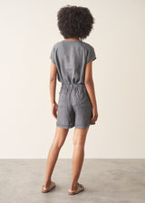 Woman wearing a checked linen top and matching checked linen shorts against a plain background