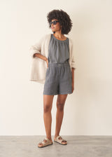 Woman wearing a checked linen top and matching checked linen shorts against a plain background
