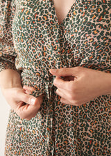 Woman wearing leopard print wrap midi dress and sandals
