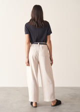 Woman wearing grey v-neck t-shirt and off white barrel leg trousers