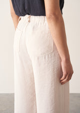Woman wearing grey v-neck t-shirt and off white barrel leg trousers