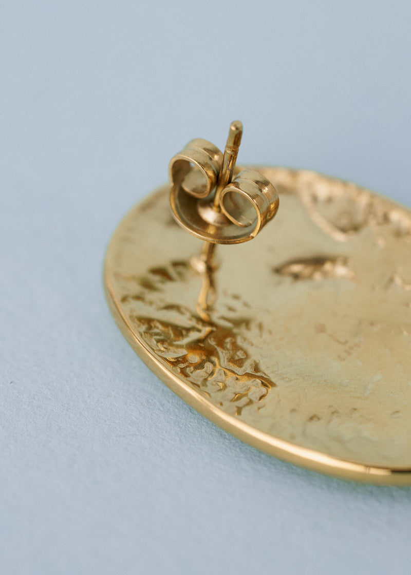 Close up of stud on gold hammered earring