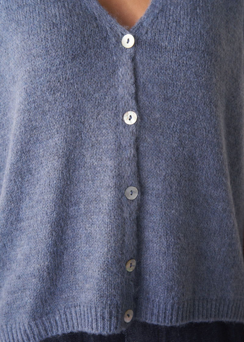 Woman wearing a blue sleeveless knitted waistcoat 