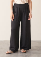 Woman wearing black wide leg trousers with nude camisole and light cardigan