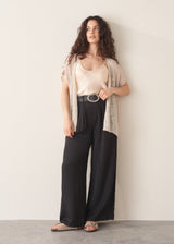 Woman wearing black wide leg trousers with nude camisole and light cardigan
