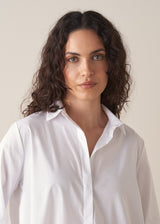 Woman wearing an oversized white shirt and grey stripe trousers