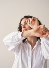Woman wearing an oversized white shirt and grey stripe trousers