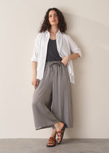 Woman wearing white shirt and stripe wide leg cropped trousers