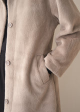 Close up of women's hand in pocket of an oversized faux fur oatmeal coat