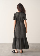 Woman wearing a black checkered dress against a plain background