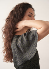 Woman wearing a patterned dress on a plain background