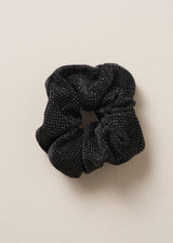 Black glittery hair scrunchie on a beige background