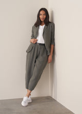Woman wearing a khaki linen blazer and barrel leg linen trousers