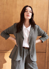 Woman wearing a khaki linen blazer and barrel leg linen trousers