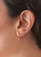 Gold hoop earrings with red crystal detail