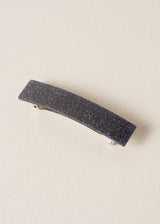 Women's black glitter hair clip on a beige background
