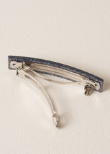 Women's black glitter hair clip on a beige background