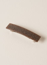 Brown glittery hair clip on beige backgroun