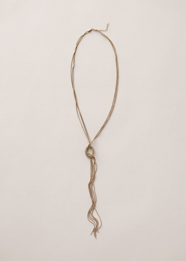 Gold chain knot necklace on a beige background