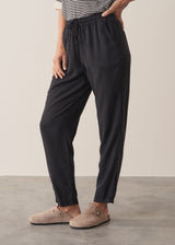 Woman wearing stripe sweater and black tapered drawstring trousers