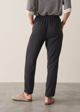 Woman wearing stripe sweater and black tapered drawstring trousers