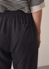 Woman wearing stripe sweater and black tapered drawstring trousers