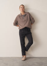 Woman wearing stripe sweater and black tapered drawstring trousers