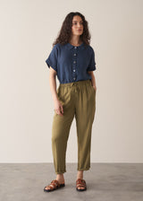 Woman wearing olive green trousers and blue linen shirt