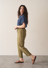 Woman wearing olive green trousers and blue linen shirt