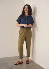 Woman wearing olive green trousers and blue linen shirt