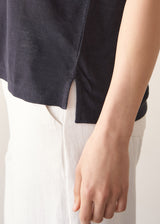 Woman wearing dark grey linen v-neck t-shirt and white jeans