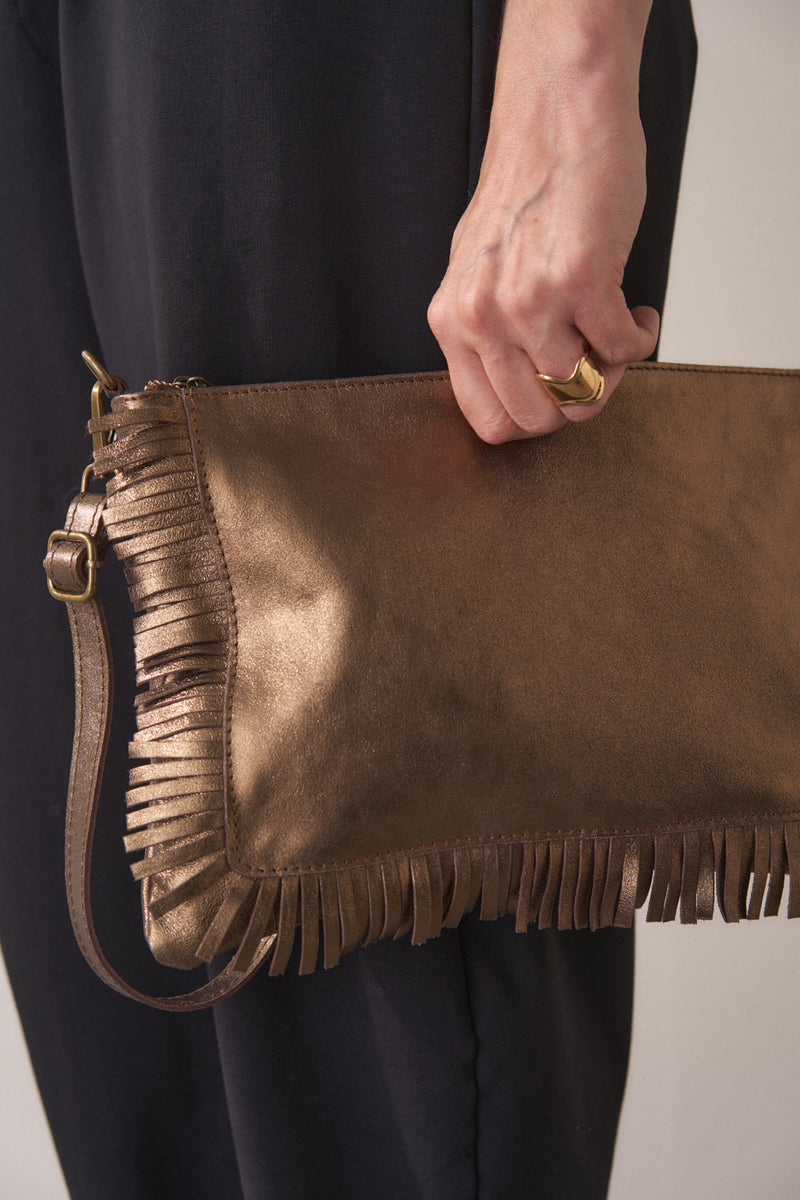 Bronze-coloured leather clutch bag with fringe details on a light gray background