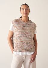 Woman wearing space dye knitted vest top with white t-shirt and light trousers