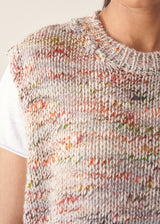 Woman wearing space dye knitted vest top with white t-shirt and light trousers