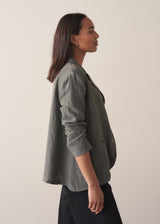 Woman wearing a khaki linen blazer and barrel leg linen trousers