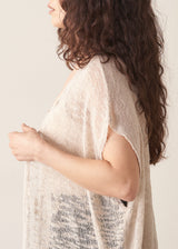 Woman wearing light beige cardigan with black trousers