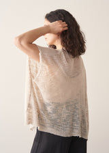 Woman wearing light beige cardigan with black trousers