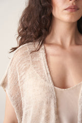 Woman wearing light beige cardigan with black trousers