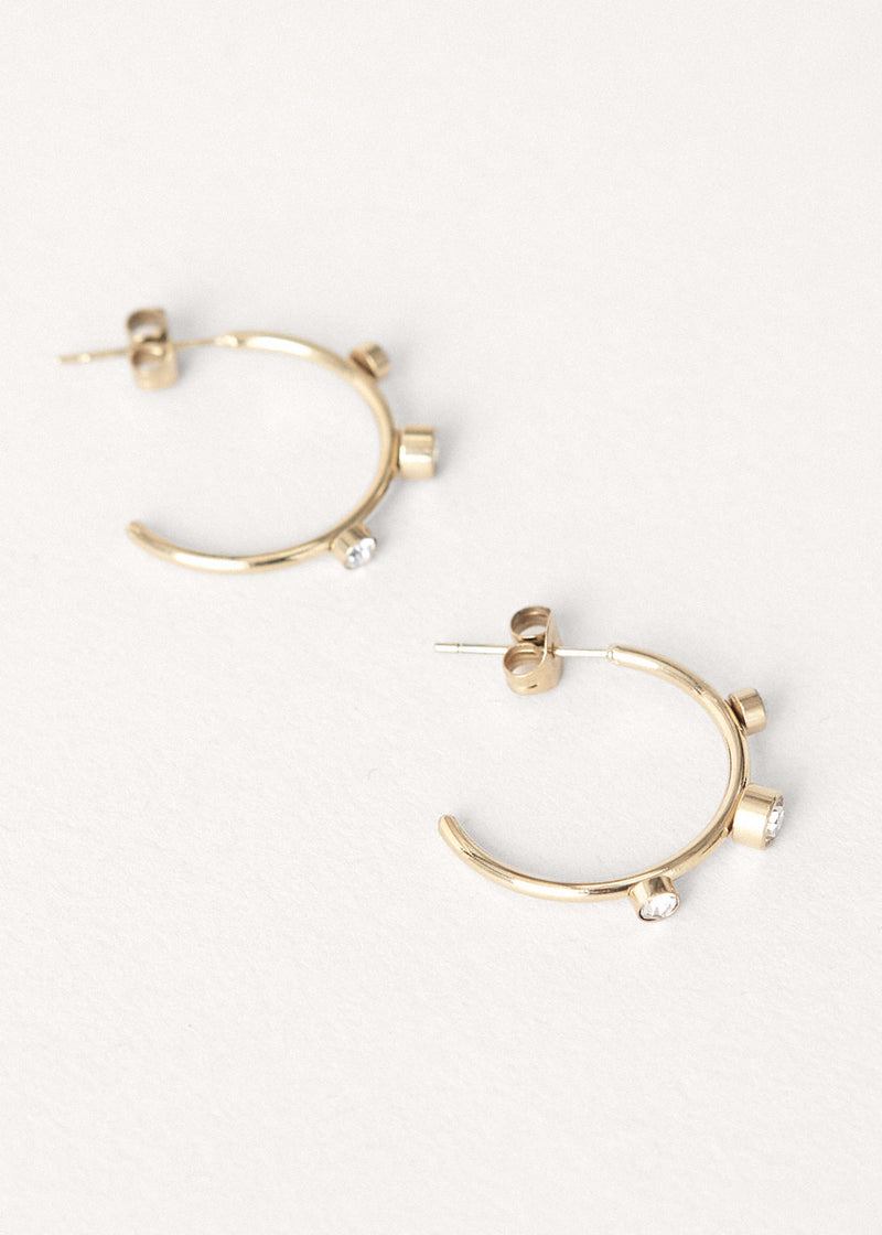 Contemporary gold stud hoop earrings with crystal detail on white background