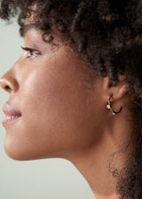 Woman wearing contemporary gold stud hoop earrings with crystal detail