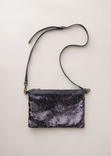 Black sequin clutch bag on a light beige background